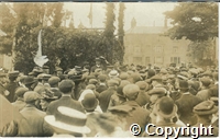 Postcard featuring black and white photograph of a crowd gathered in front of the well dressing on Buxton market place. A handwritten note on the back reads : Higher Buxton protest meeting against discontinuing Wells Dressing.