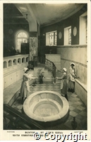 Postcard featuring a black and white photograph of three women in the pump room at St Ann's Well in Buxton.