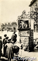 Postcard featuring a black and white photograph of a Punch and Judy Show in the Crescent, Buxton. St Anns Well visible in the background.