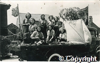 Postcard featuring a black and white photograph of 1st Buxton Rangers Girl Guides on their float during the well dressing festival parade, possibly in 1933