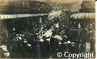 Postcard featuring a black and white photograph of crowds gathered in Spring Gardens, Buxton