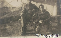 Postcard: black and white photograph of two men seated beside a tent. 'Salonica - 1918' written in pencil underneath