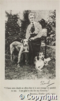 Black and white photograph of Edith Cavell seated in a garden with two dogs