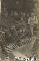 Black and white photographs of six German soldiers in a trench, one holding a cat