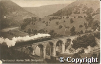 Postcard featuring a black and white photograph of Monsal Dale, showing a steam train running across the railway viaduct